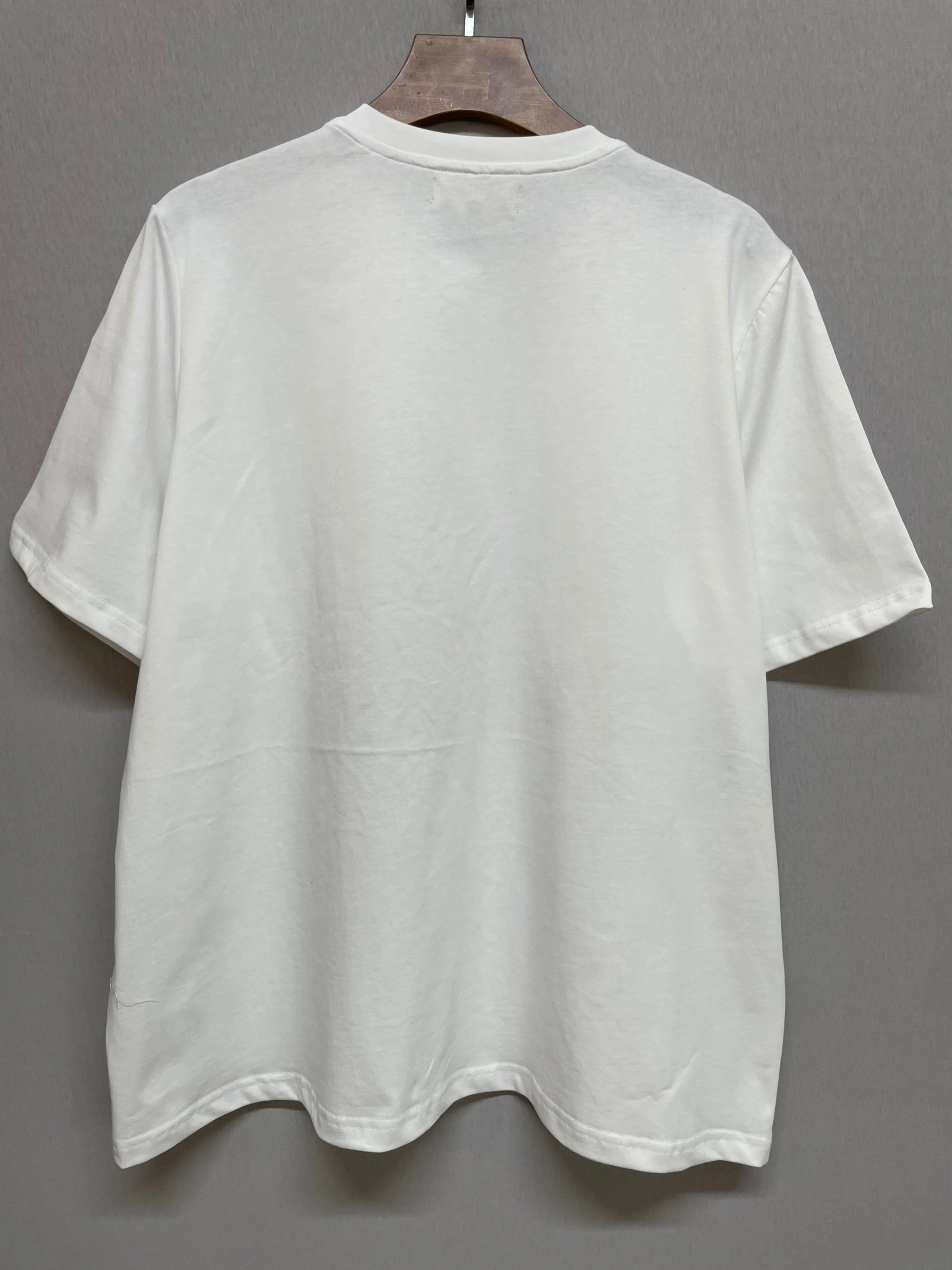 Back view of The Princess Kitten Tee on hanger, displaying the plain white cotton fabric and relaxed oversized fit.