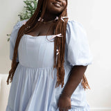 Close-up of Alice Blue Josephine Midi Dress highlighting puff sleeves and corset bodice. Blue midi dress with delicate coquette details.