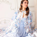 Alice Blue Josephine Midi Dress paired with a floral sheer cape, showcasing soft coquette fashion. Blue midi dress styled for romantic elegance.
