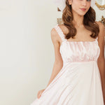 Ballerina Pink Satin Midi Dress featuring ruched straps and flowing satin fabric, styled with soft curls and pink makeup for a dreamy look.