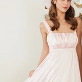 Ballerina Pink Satin Midi Dress featuring ruched straps and flowing satin fabric, styled with soft curls and pink makeup for a dreamy look.