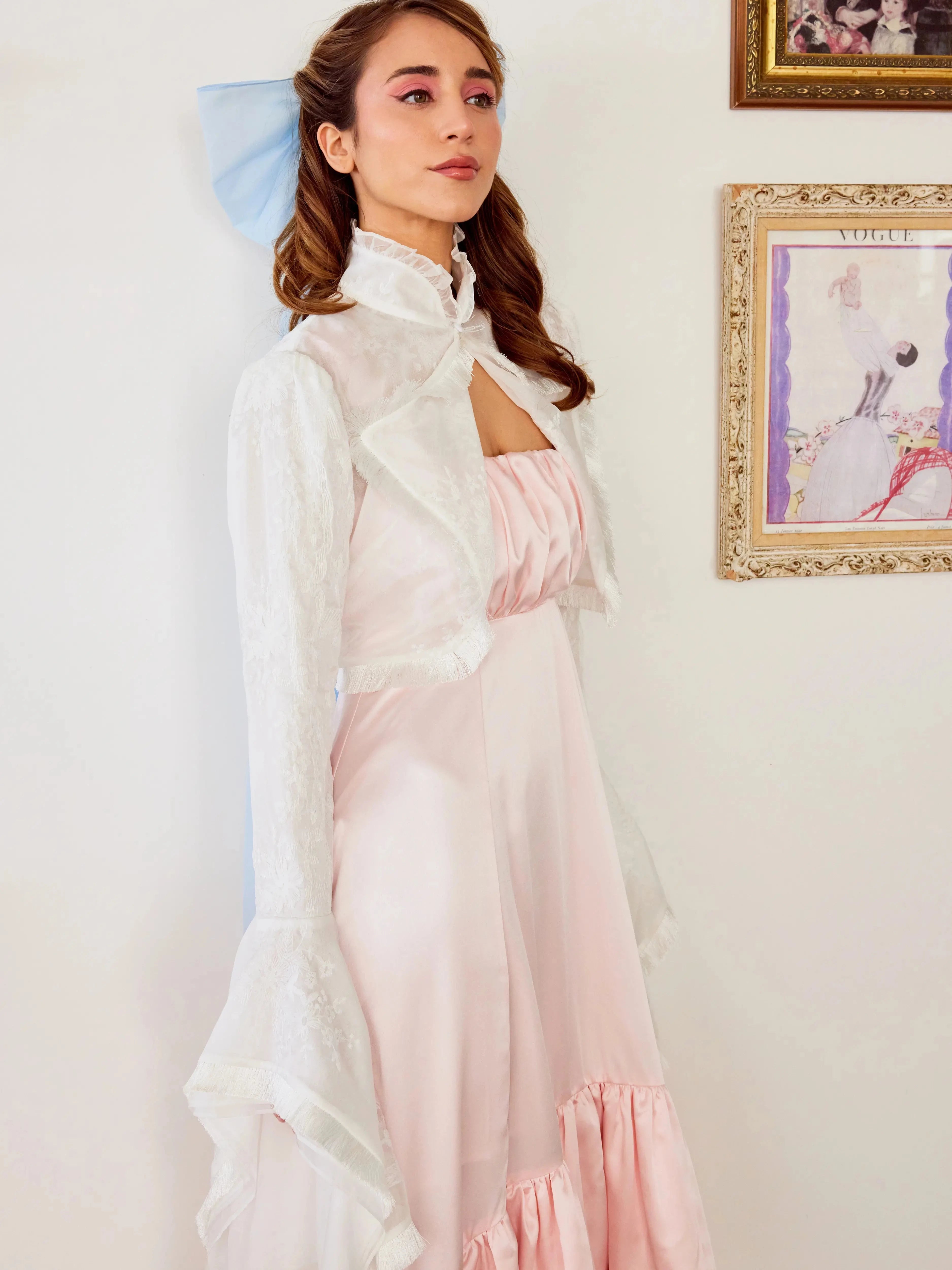 Ballerina Pink Satin Midi Dress paired with a white lace bolero, highlighting the ruched neckline and soft pastel aesthetic in a vintage setting.