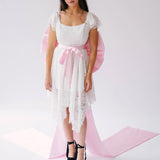White lace dress with pink bow sash belt and black platform heels for a chic look
