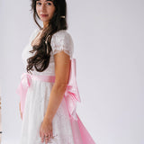 White lace dress with Ballet Pink Bow Sash Belt for a stylish look.