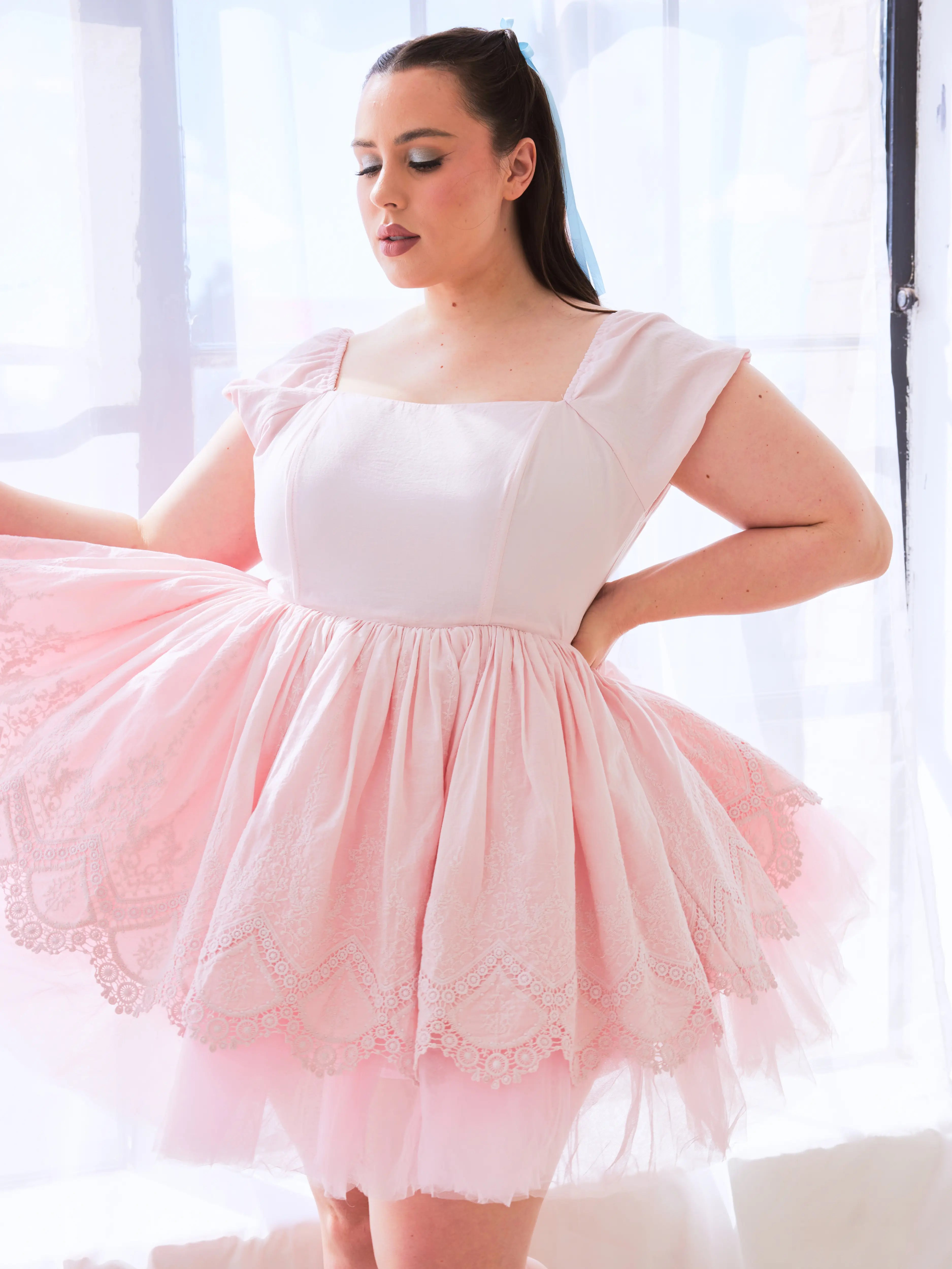 The Blossom Soft Pink Mini Dress is a pale pink tulle mini dress with lace overlay and empire waist.