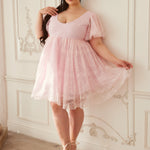 Model twirling in the Cherub Pink Lace Dress, highlighting the airy lace fabric and romantic mini dress design from the In-Bloom Collection N.3.