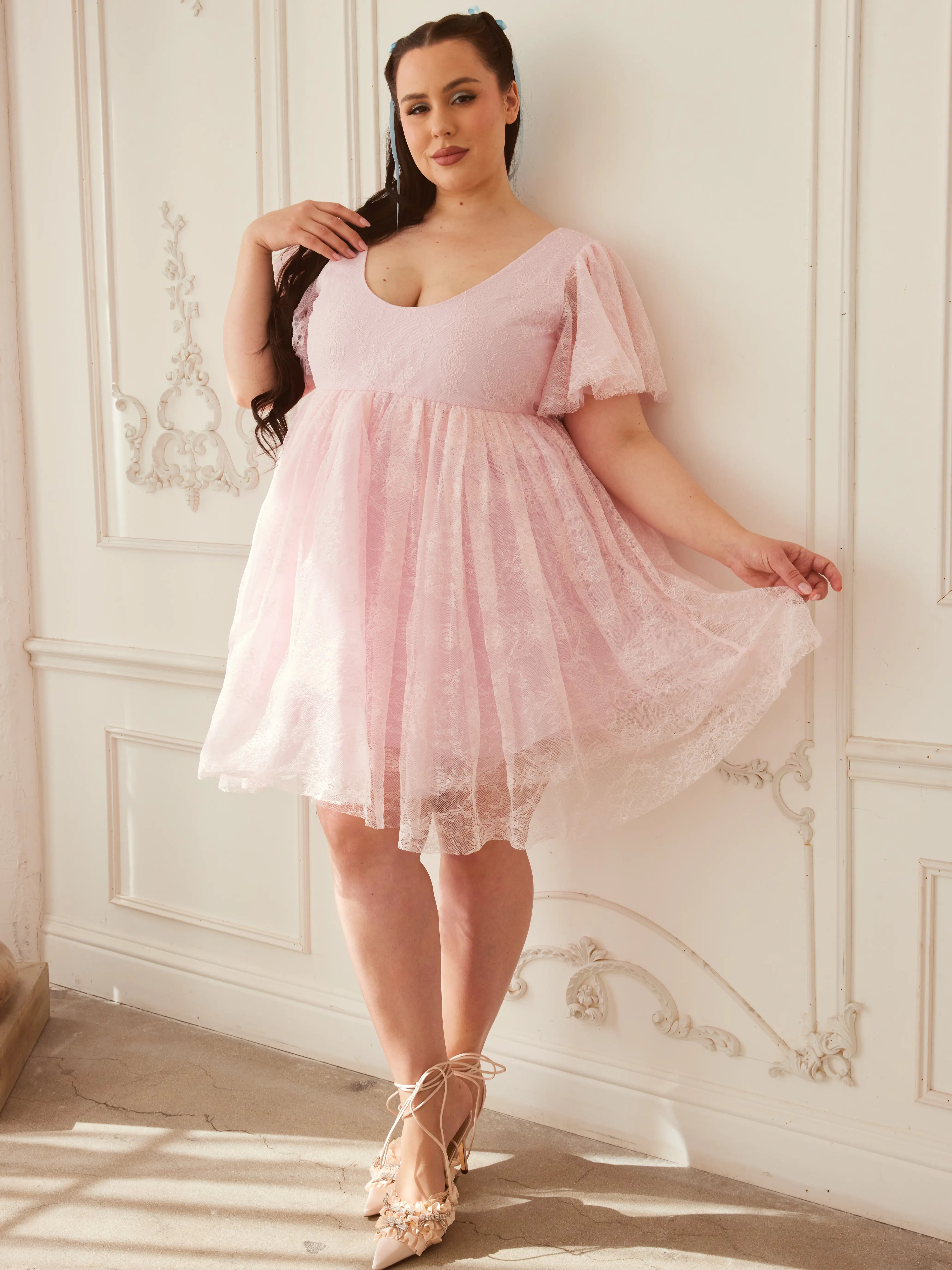 Model twirling in the Cherub Pink Lace Dress, highlighting the airy lace fabric and romantic mini dress design from the In-Bloom Collection N.3.