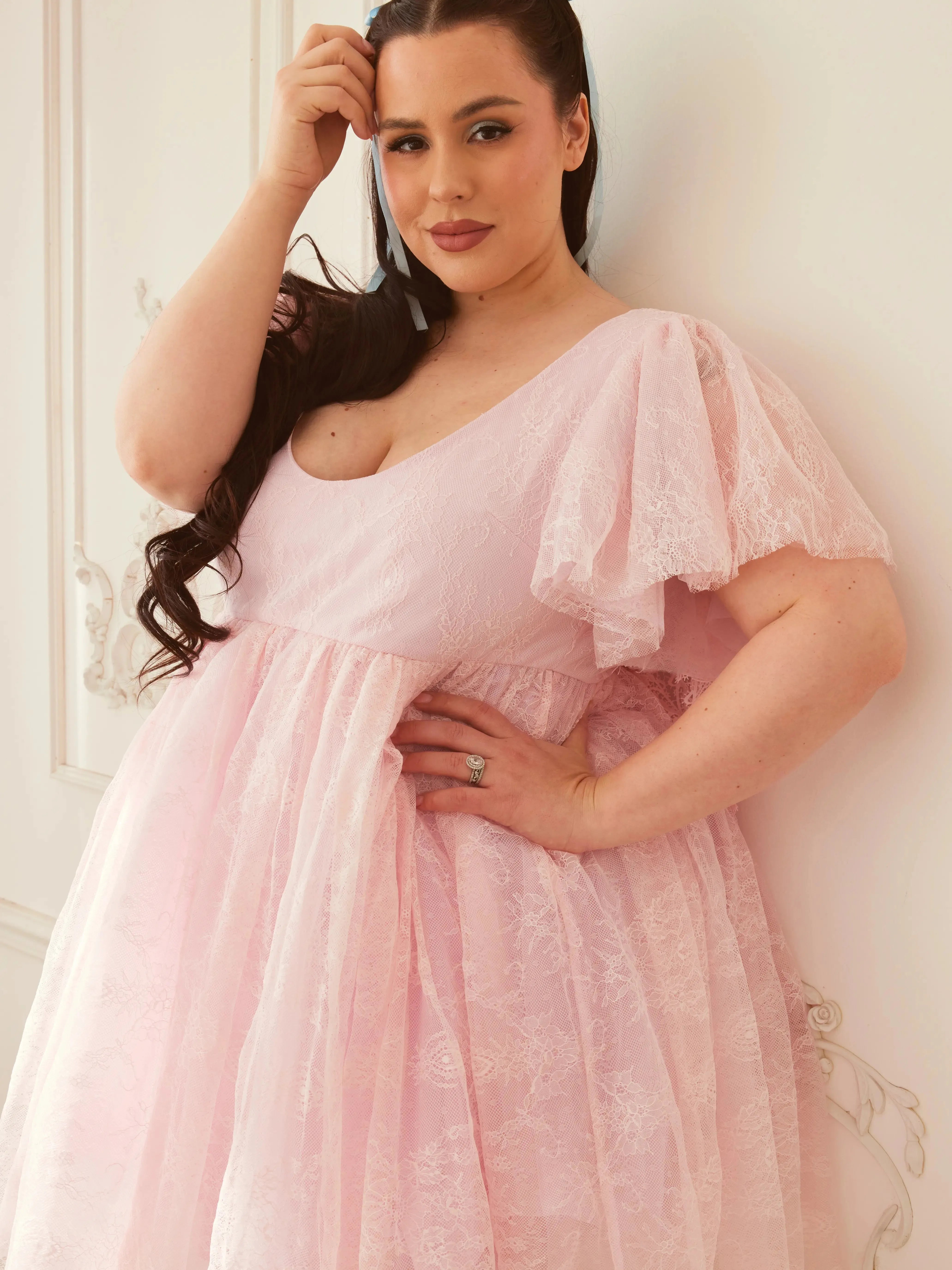 Close-up of the Cherub Pink Lace Dress showing delicate lace texture, soft flutter sleeves, and flattering sweetheart neckline.
