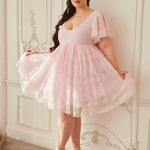 the Cherub Pink Lace Dress styled with lace-up heels, showcasing its flowy skirt and feminine silhouette in a vintage-inspired room.