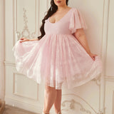 the Cherub Pink Lace Dress styled with lace-up heels, showcasing its flowy skirt and feminine silhouette in a vintage-inspired room.