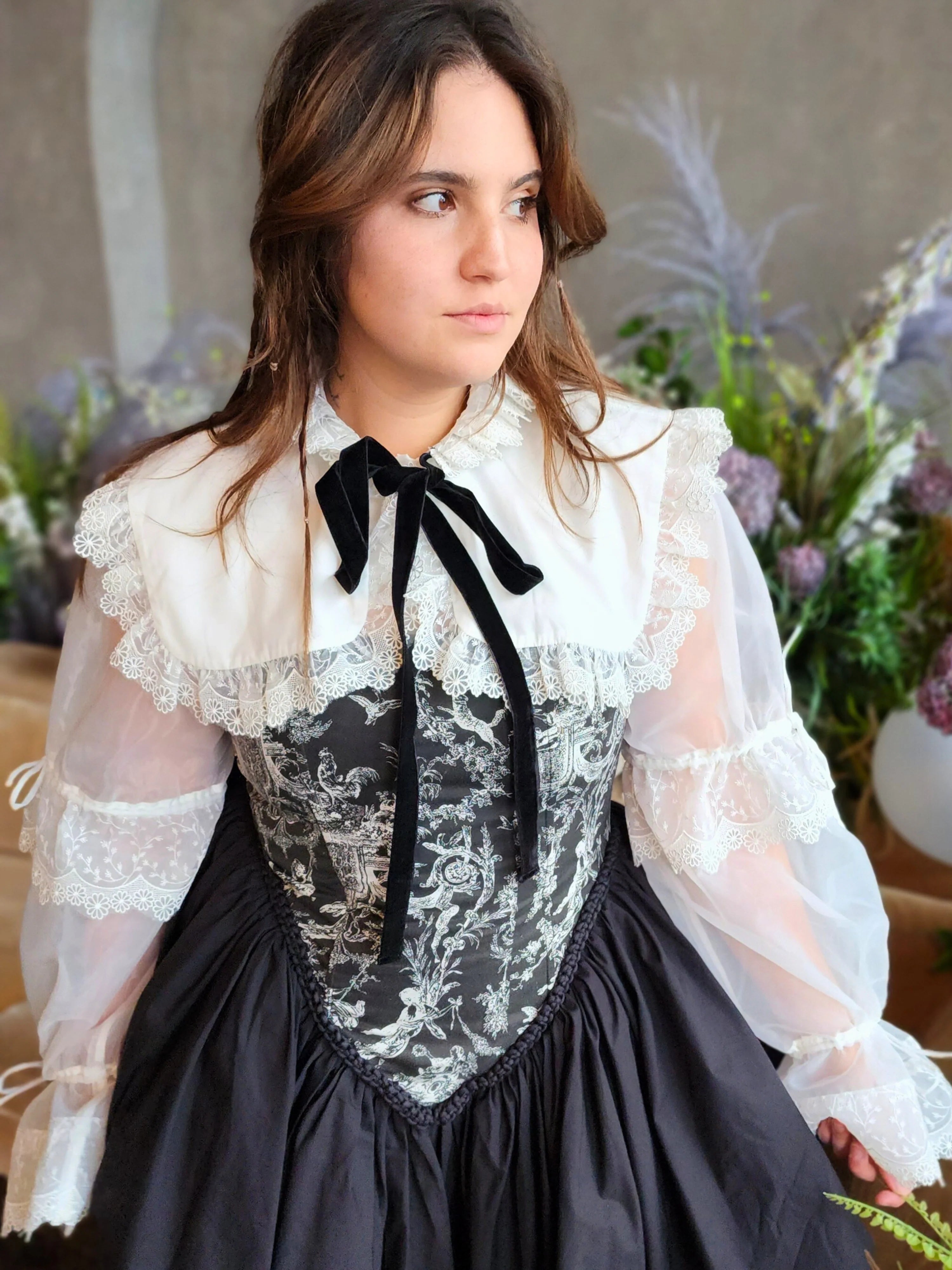 Woman in Victorian-style corset gown underneath the Ciela Snow White Shrug with lace trim and bow tie