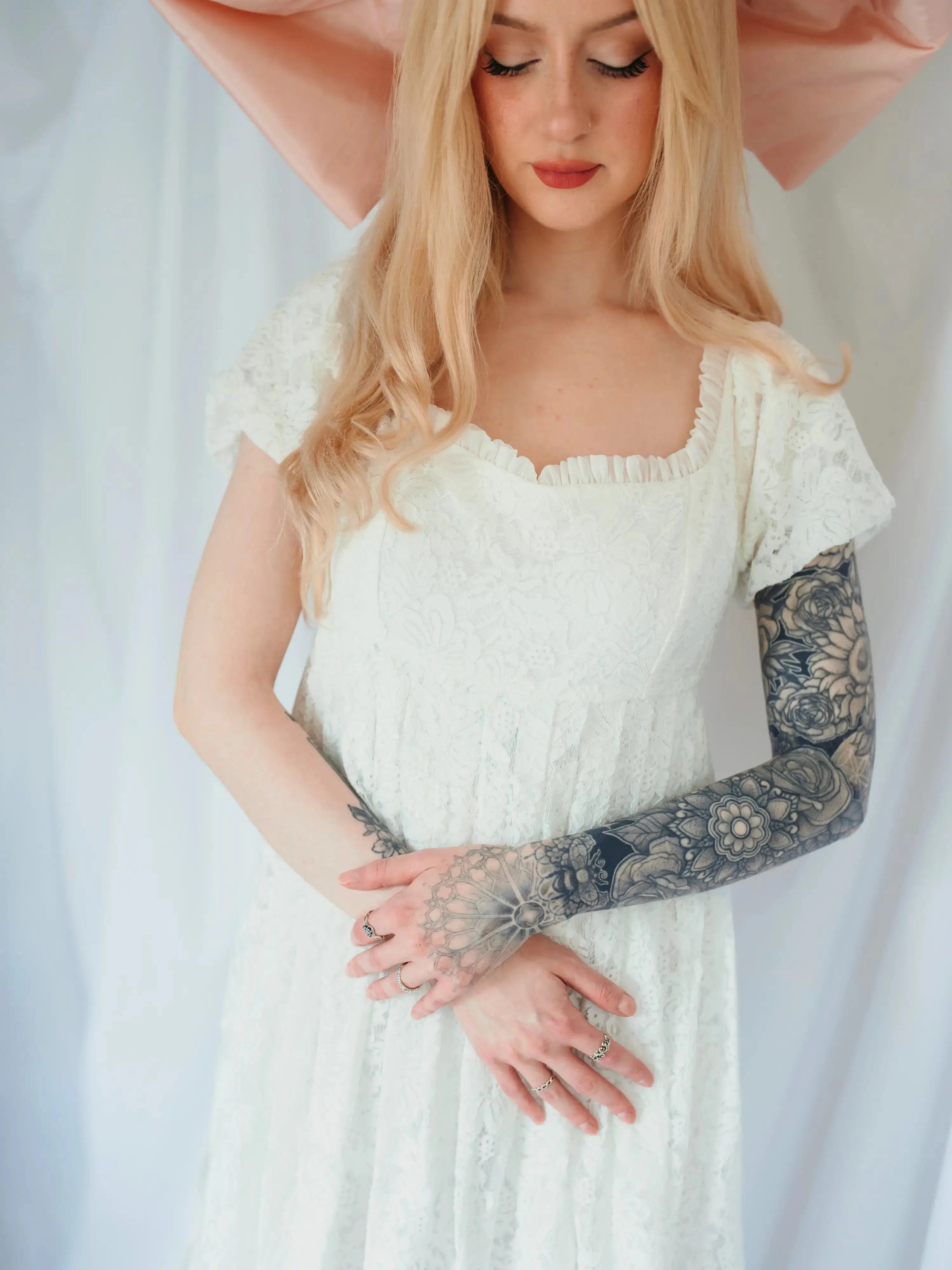 Close-up of Dauphine Lace Gown's bodice and ruffled neckline, showcasing delicate lace and soft bridal elegance.