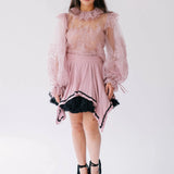 Eleanor Dusty Pink Lace Blouse with sheer puff sleeves, floral appliqués, and ruffle collar, styled with a flared skirt for romantic layering.