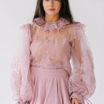 Front close-up of Eleanor Dusty Pink Lace Blouse showcasing sheer lace, puff sleeves, and ruffle collar, ideal for romantic and layered styling.