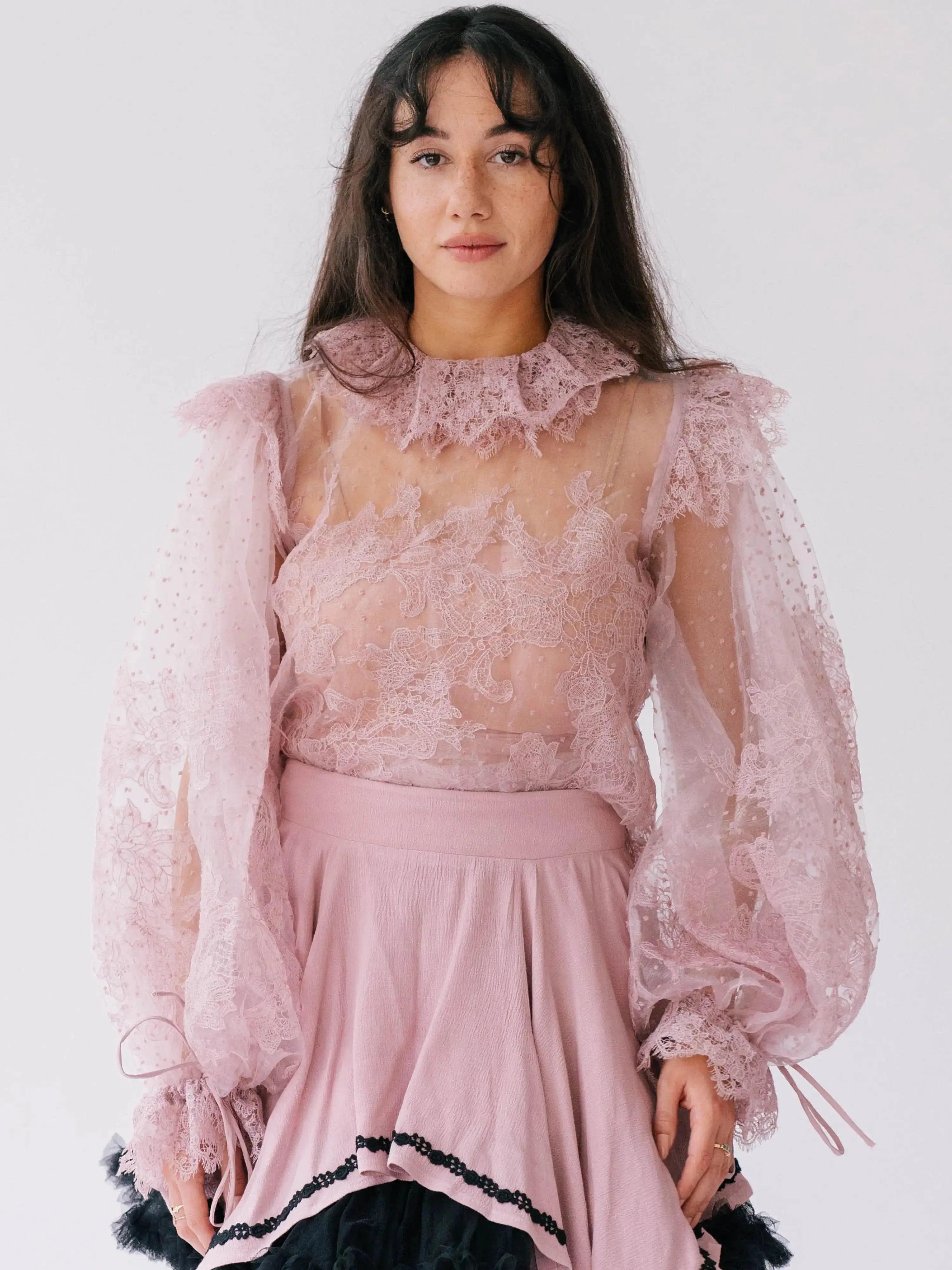 Front close-up of Eleanor Dusty Pink Lace Blouse showcasing sheer lace, puff sleeves, and ruffle collar, ideal for romantic and layered styling.
