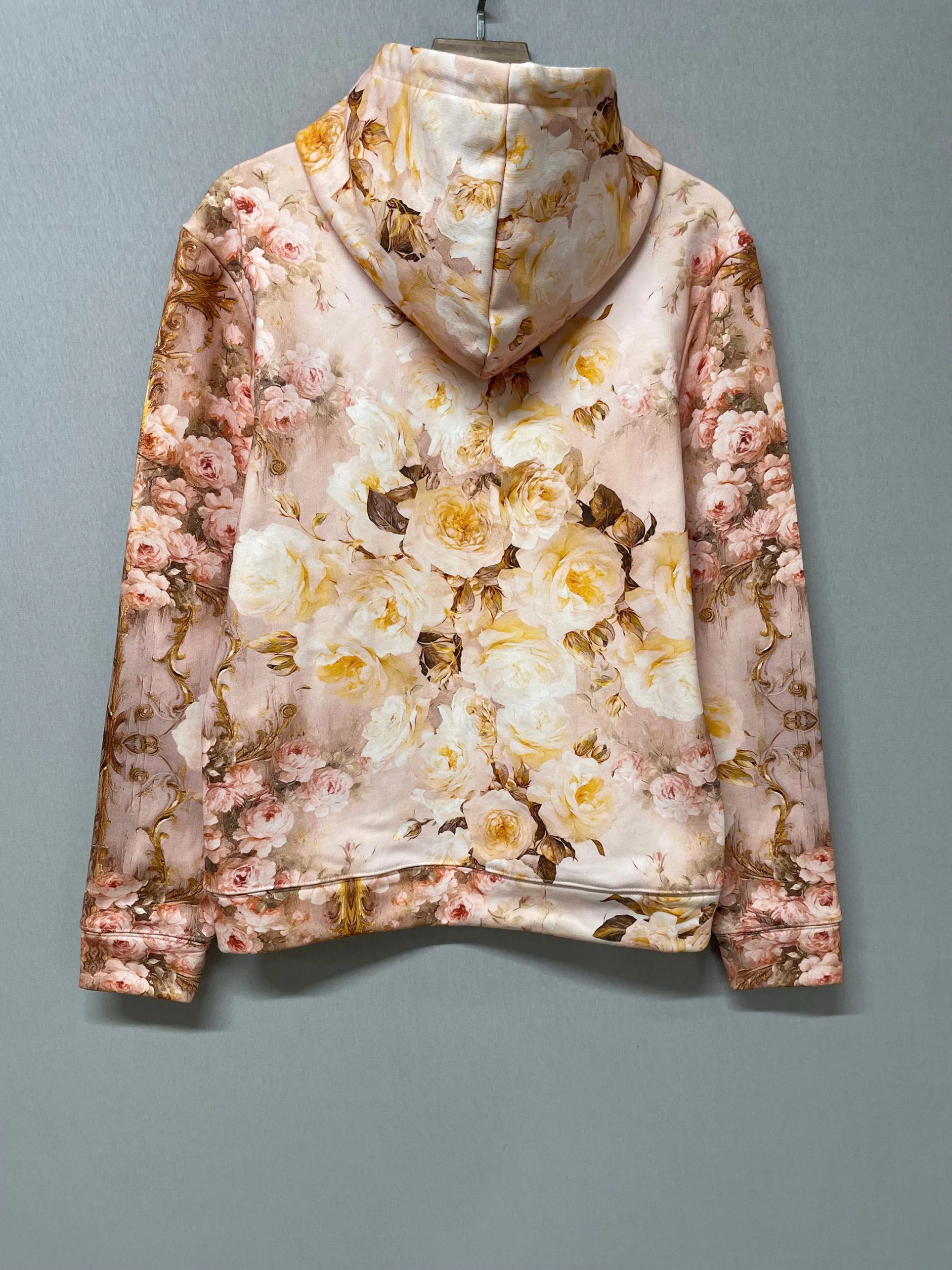 Back view of The Twilight Bloom Sleeper Hoodie on hanger, highlighting full floral print. Soft cotton hoodie perfect for floral fashion lovers.
