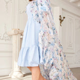 Side view of The High Priestess Renaissance Cloak cascading over a blue midi dress, highlighting its voluminous and romantic drape.
