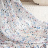 Detailed close up of the High Priestess Renaissance Cloak featuring flowing floral organza fabric with soft ruffles and pastel tones.