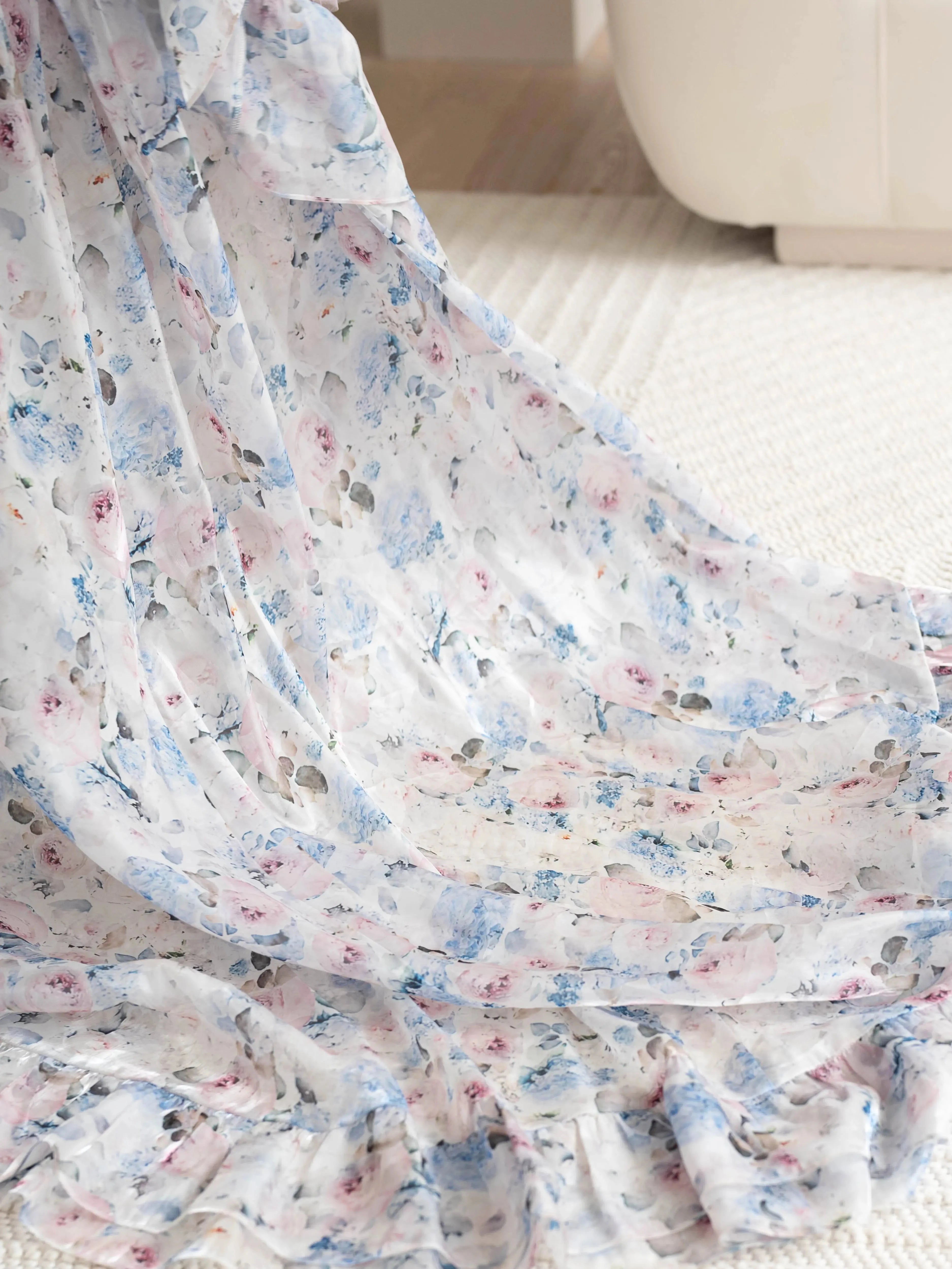 Detailed close up of the High Priestess Renaissance Cloak featuring flowing floral organza fabric with soft ruffles and pastel tones.