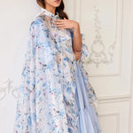 The High Priestess Renaissance Cloak worn over a pastel blue dress, highlighting the dreamy floral print and ruffled collar.