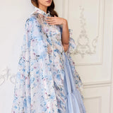 The High Priestess Renaissance Cloak worn over a pastel blue dress, highlighting the dreamy floral print and ruffled collar.