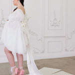 Full-length view of the Ivory Bridal Grand Bow Belt with extended satin train, styled with a short white bridal dress and pink heels.