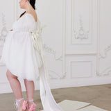 Full-length view of the Ivory Bridal Grand Bow Belt with extended satin train, styled with a short white bridal dress and pink heels.