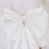 Close-up of the Ivory Bridal Grand Bow Belt showcasing intricate satin folds and secure clip detail for elegant bridal styling.