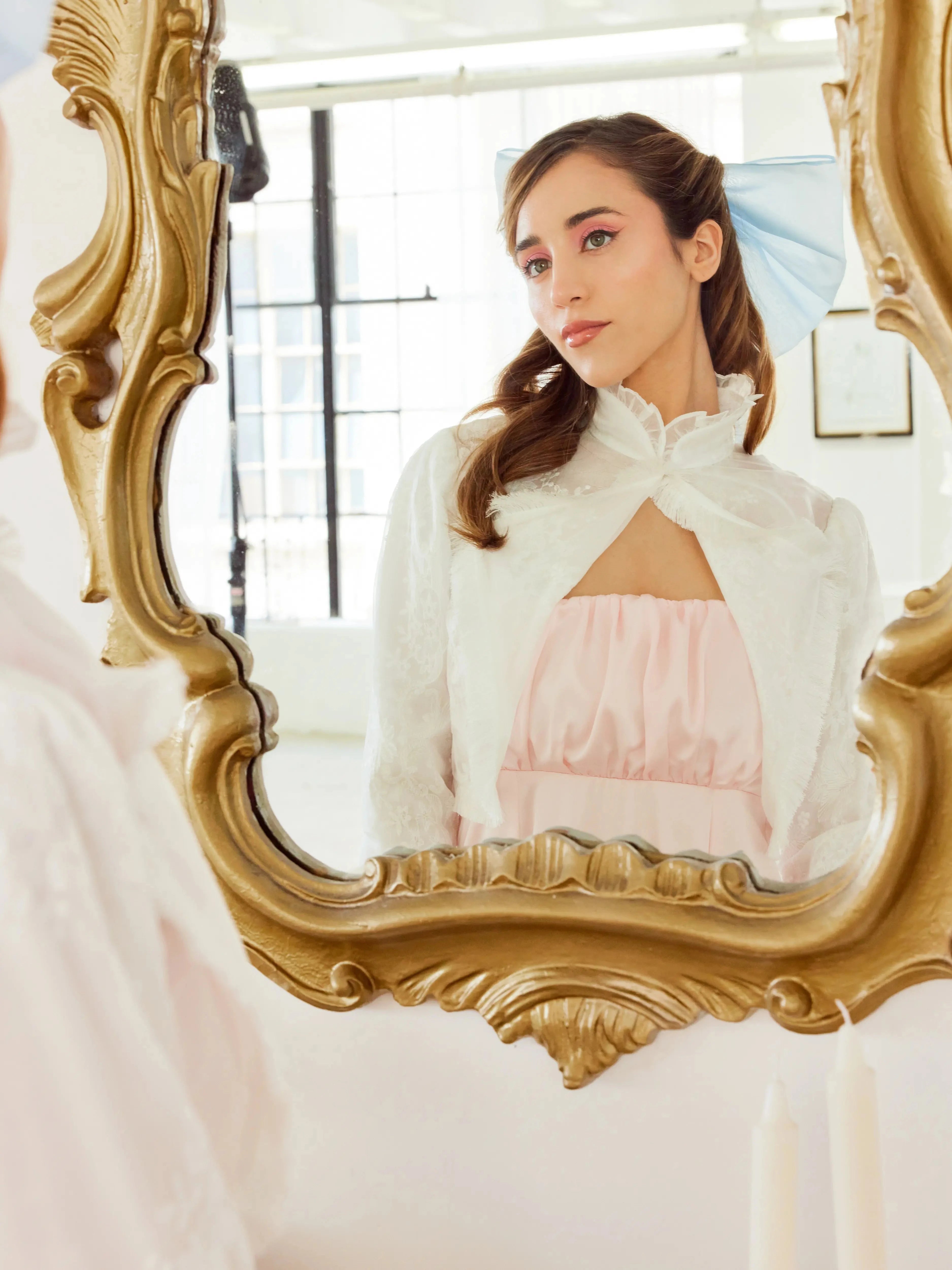 Ivory Lady Elizabeth Bolero Jacket reflected in ornate mirror, highlighting its romantic high collar and vintage-inspired silhouette.