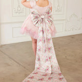 the Rosewater Grand Bow Belt with oversized floral bow and extended satin tails, styled on a pink lace dress for whimsical elegance.