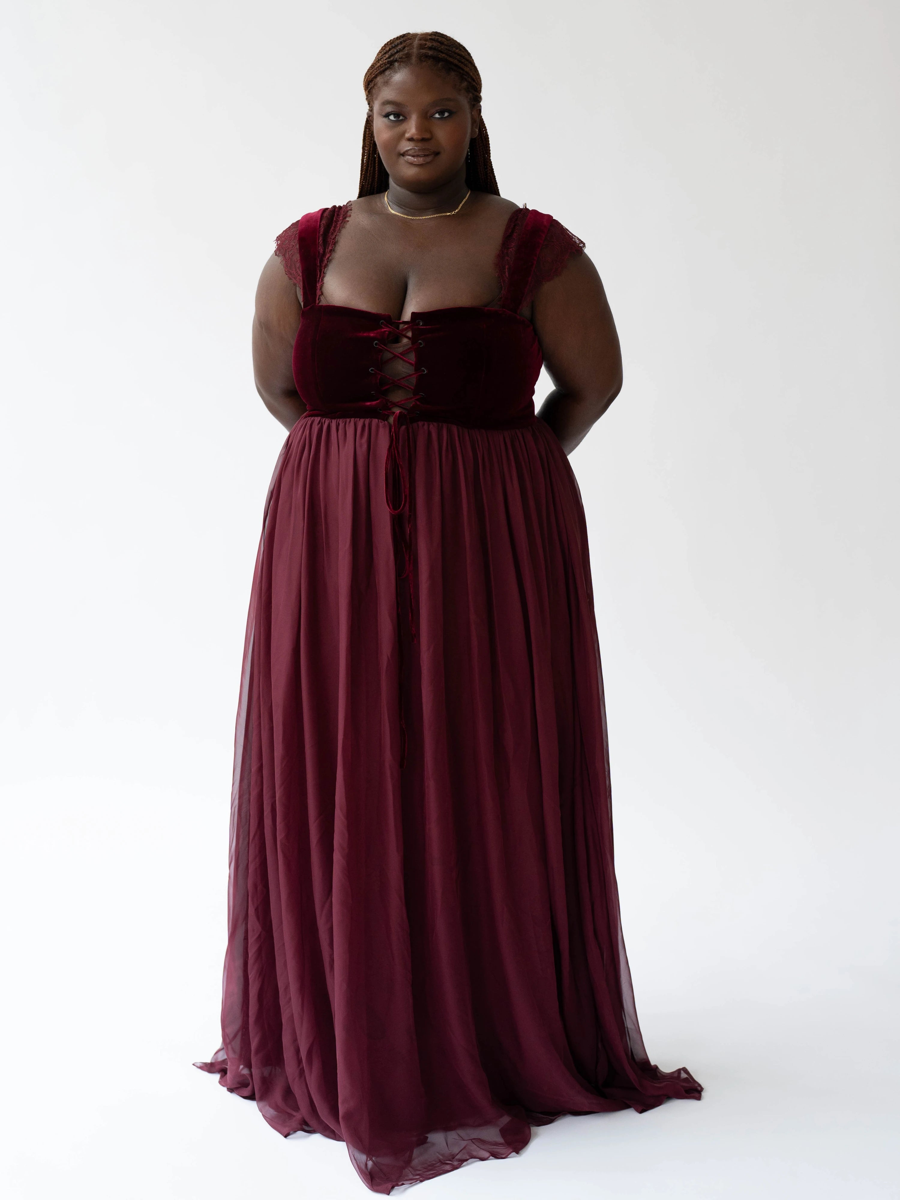 A floor-length scarlet red gown with a lace up corset bodice and flowing skirt.