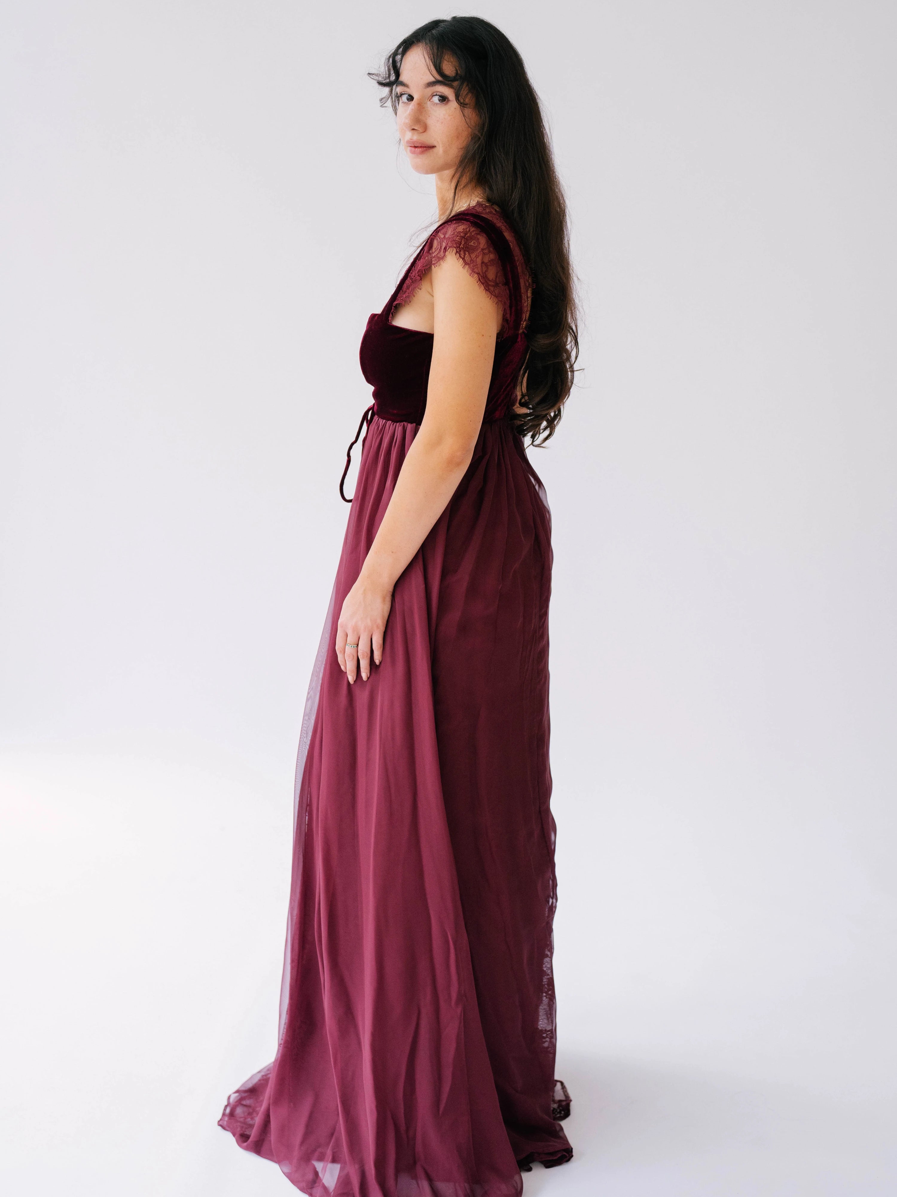 scarlet red floor-length gown with lace cap sleeves and a velvet corset bodice.