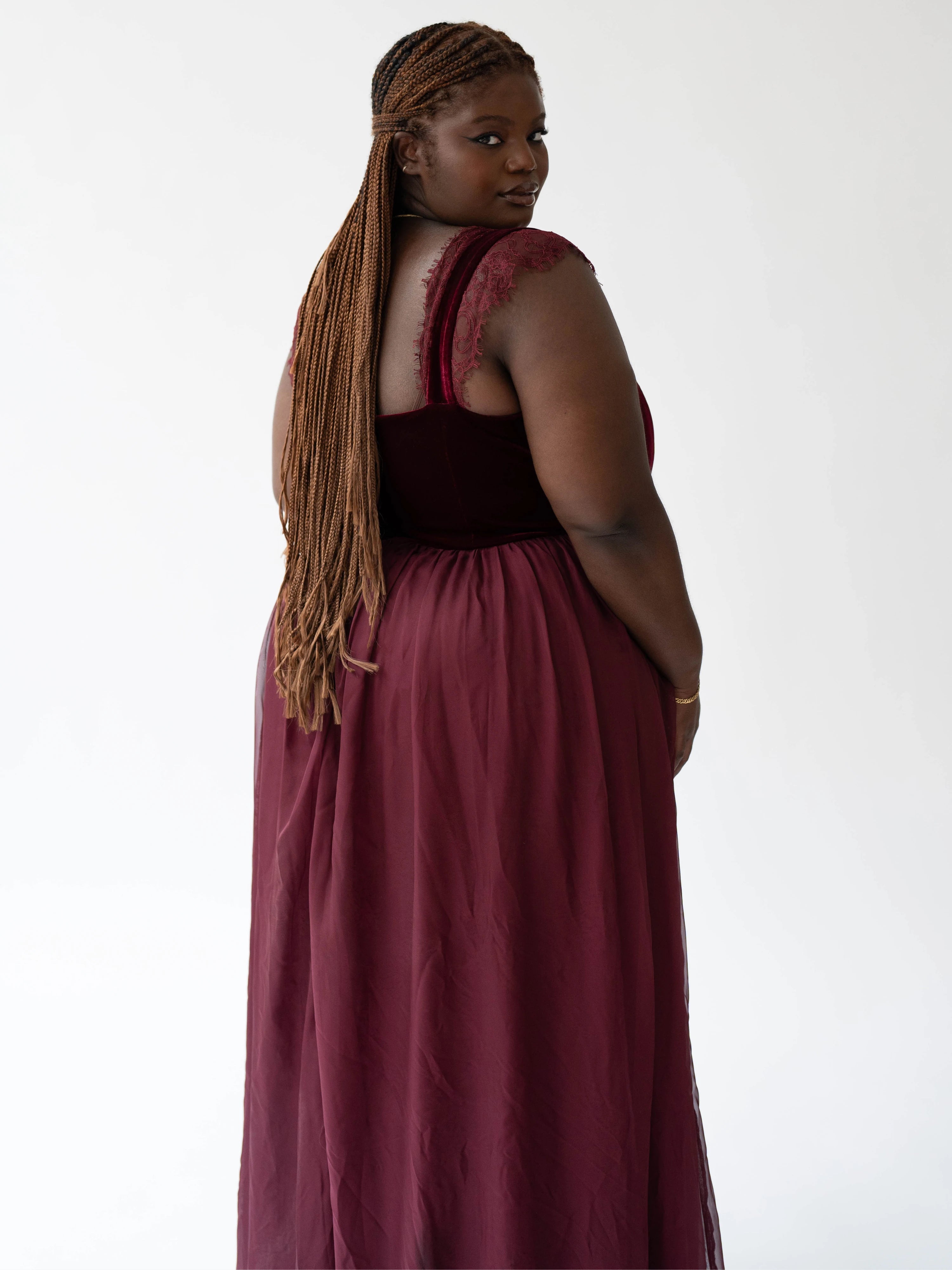 A scarlet red floor-length formal gown with a corset bodice and flowing skirt.