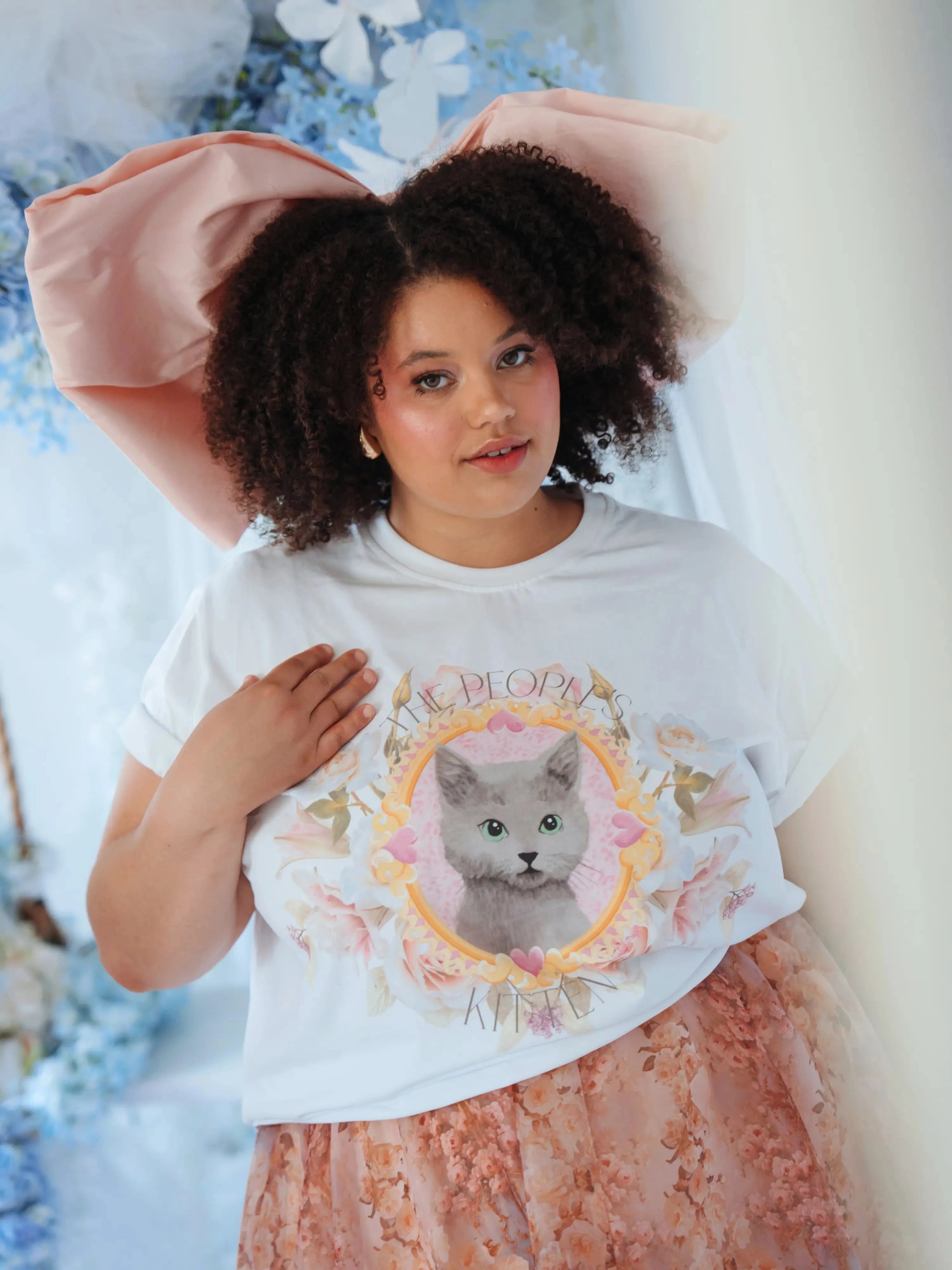 Oversized The Princess Kitten Tee worn with a large pink bow and floral skirt, showcasing a regal kitten graphic on soft cotton fabric.
