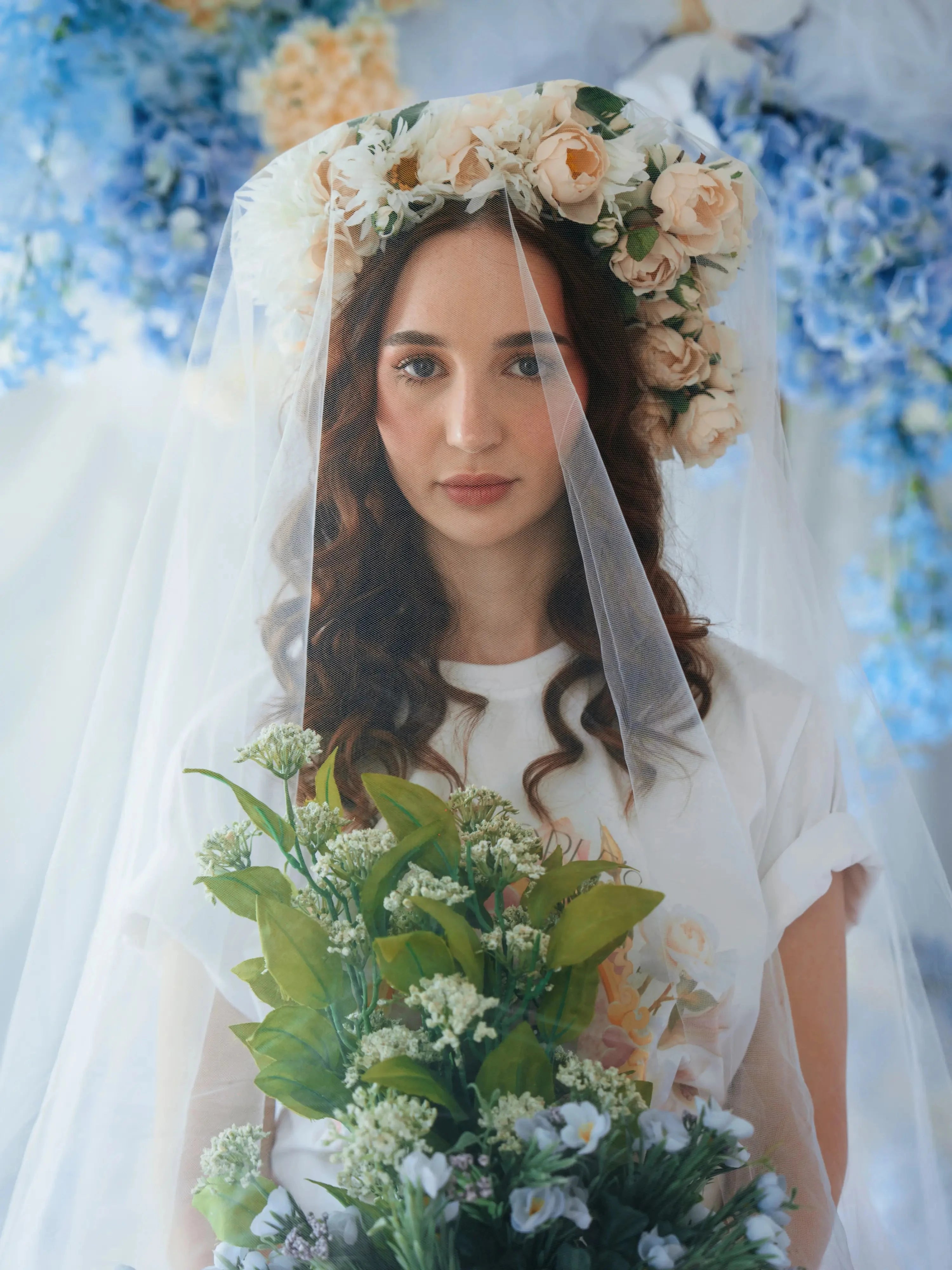 Bridal-inspired styling of The Princess Kitten Tee with a flower crown and veil, holding a bouquet to highlight the tee’s romantic charm.