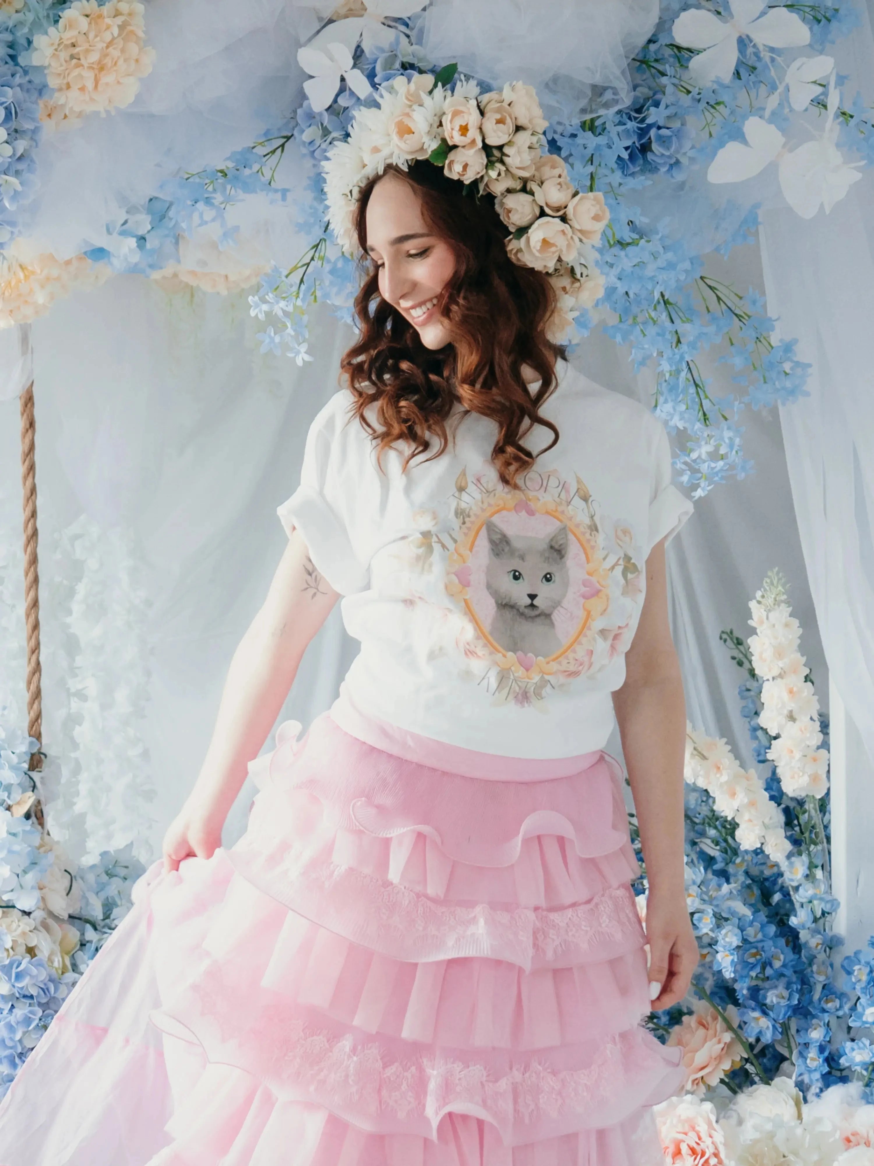 The Princess Kitten Tee styled in a pastel floral scene, paired with a pink tiered skirt and flower crown for a fairytale aesthetic.