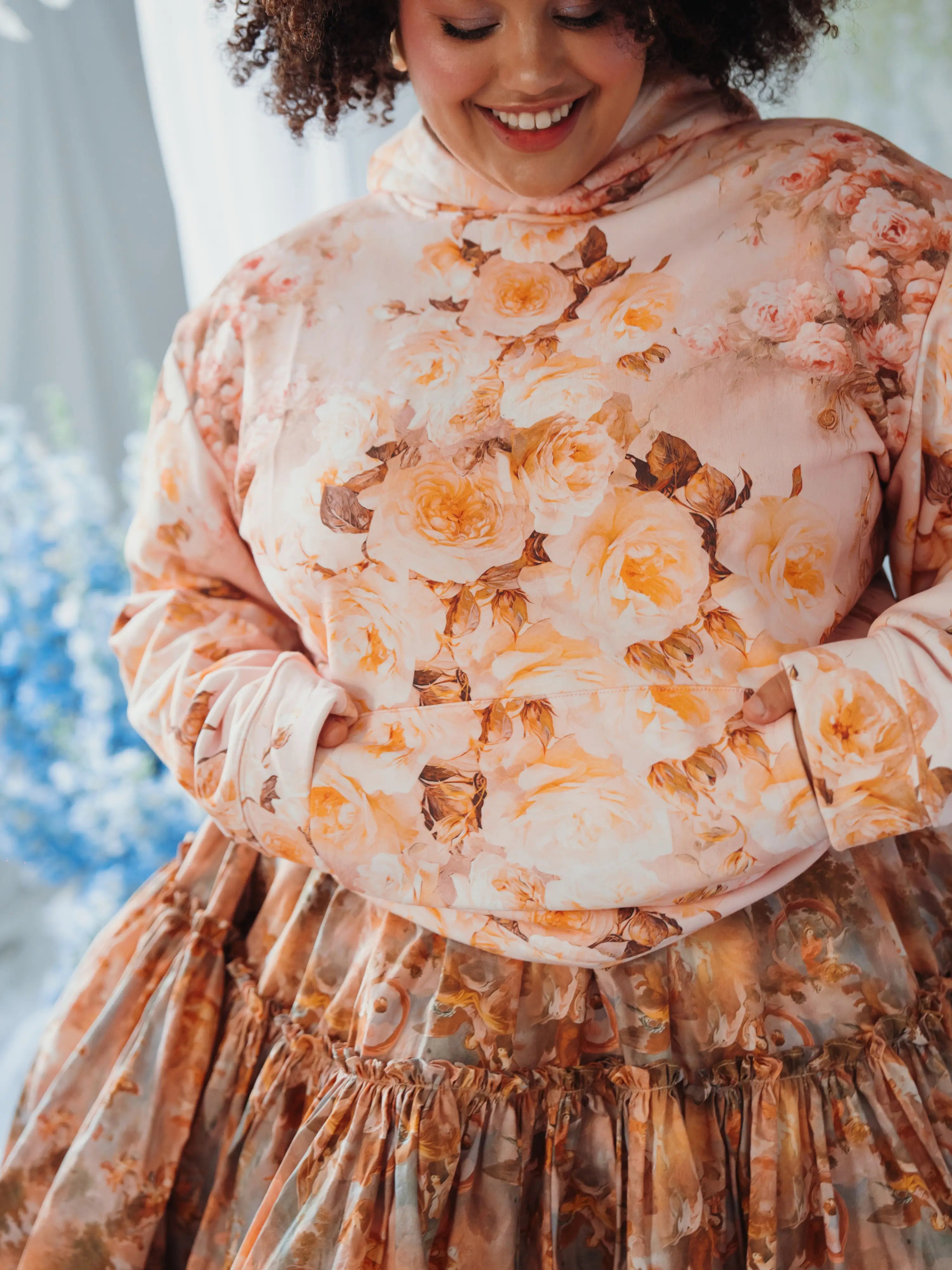 Close-up of The Twilight Bloom Sleeper Hoodie’s floral pattern and kangaroo pocket. Thick cotton fabric for ultimate cozy wear.
