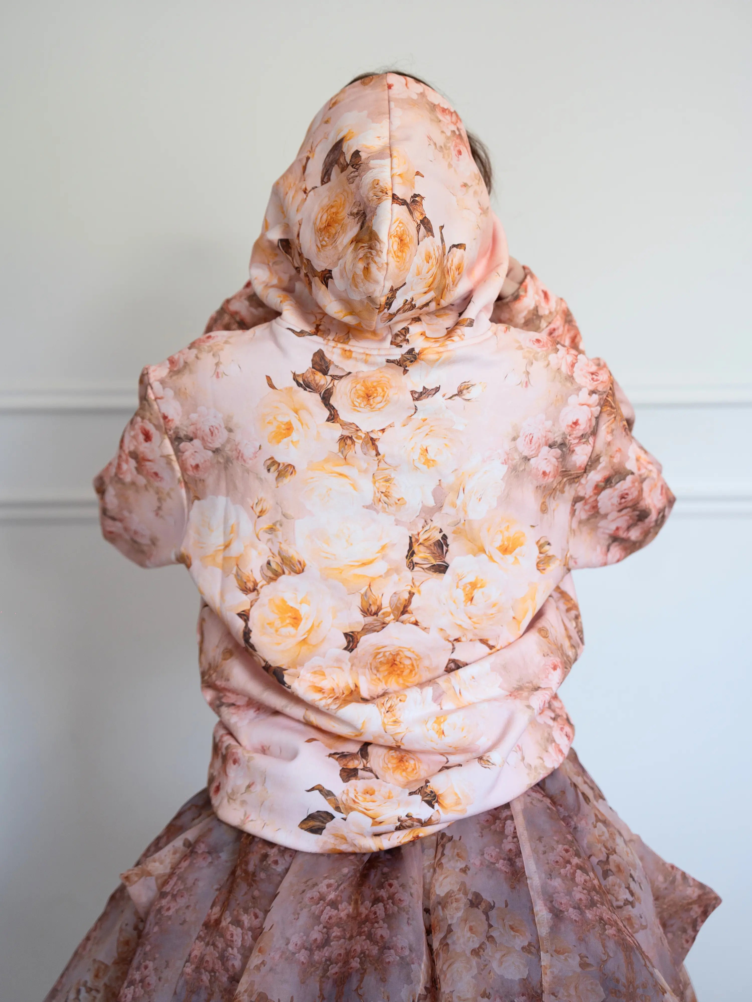 Back of The Twilight Bloom Sleeper Hoodie with hood up, highlighting yellow and blush rose print. Perfect for floral fashion enthusiasts.