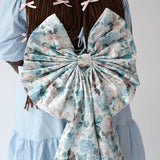 Zoomed-in back view of the Wildbloom Grand Bow Belt on braided hair model, emphasizing the structured floral bow and elegant draping.