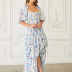 Front view of The Wildbloom Josephine Ball Gown showcasing a high-low hem and corset bodice, styled with white heels.