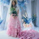 A woman wearing the dahlia pink ruffle skirt with floral decorations and a veil.