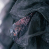 Close-up detail of the puff dresses' ghostly floral print on its poly organza fabric.