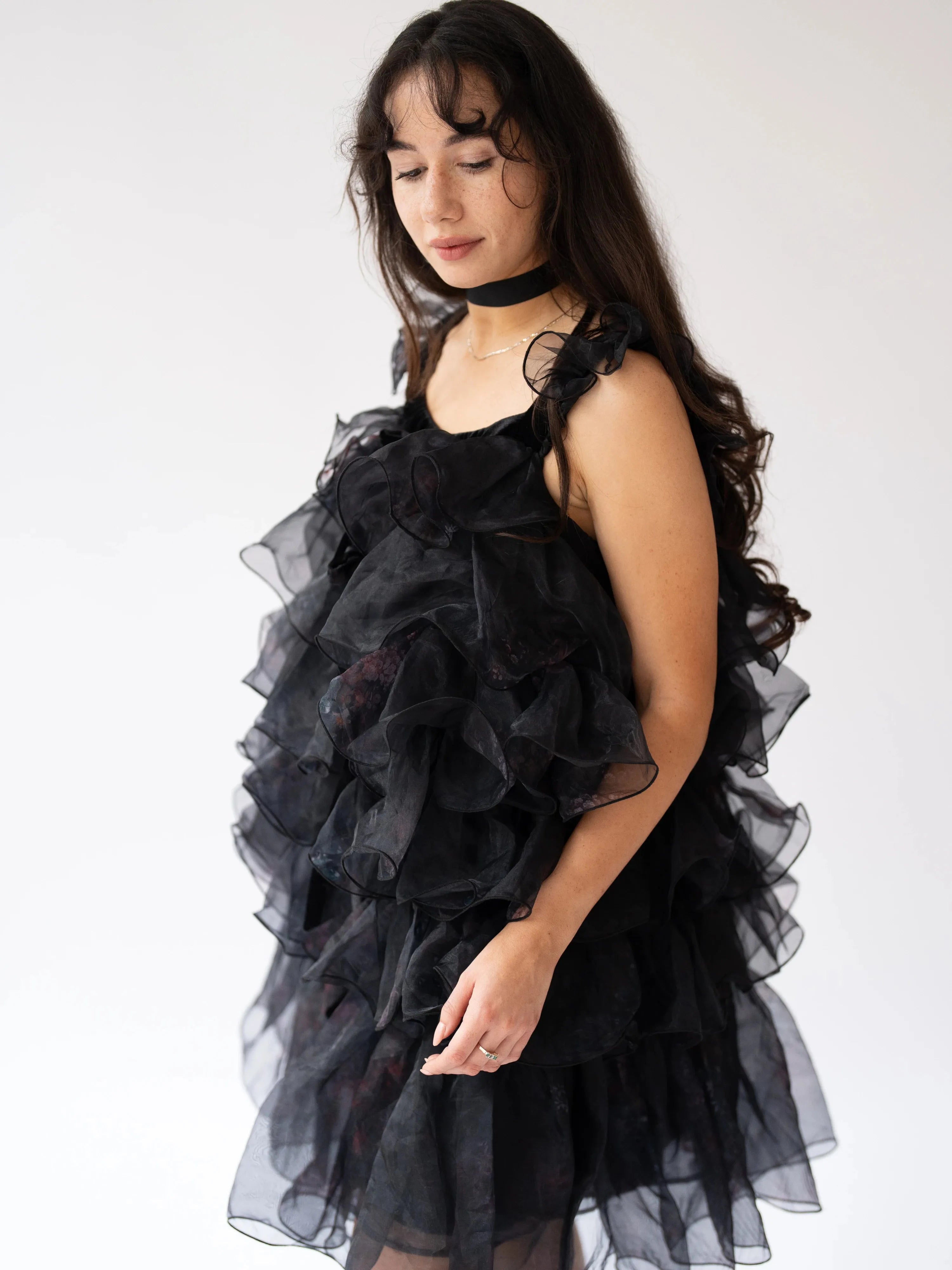 A side view of a woman wearing the light as a feather puff dress.