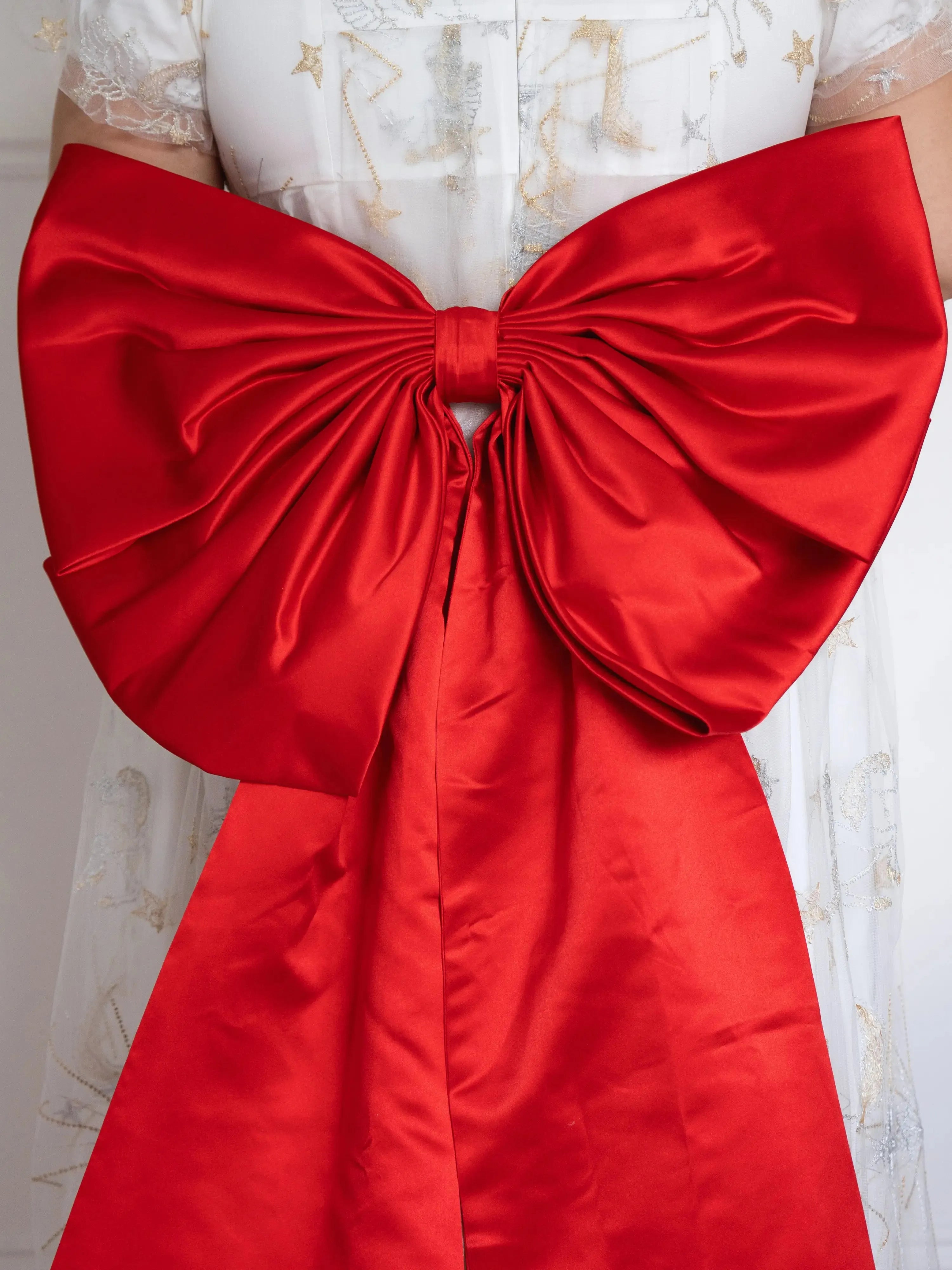 Close-up of The Holiday Red Grand Bow Belt on a plus-sized woman showing its luxurious oversized satin bow design, ideal for holiday and Valentine's Day outfits.