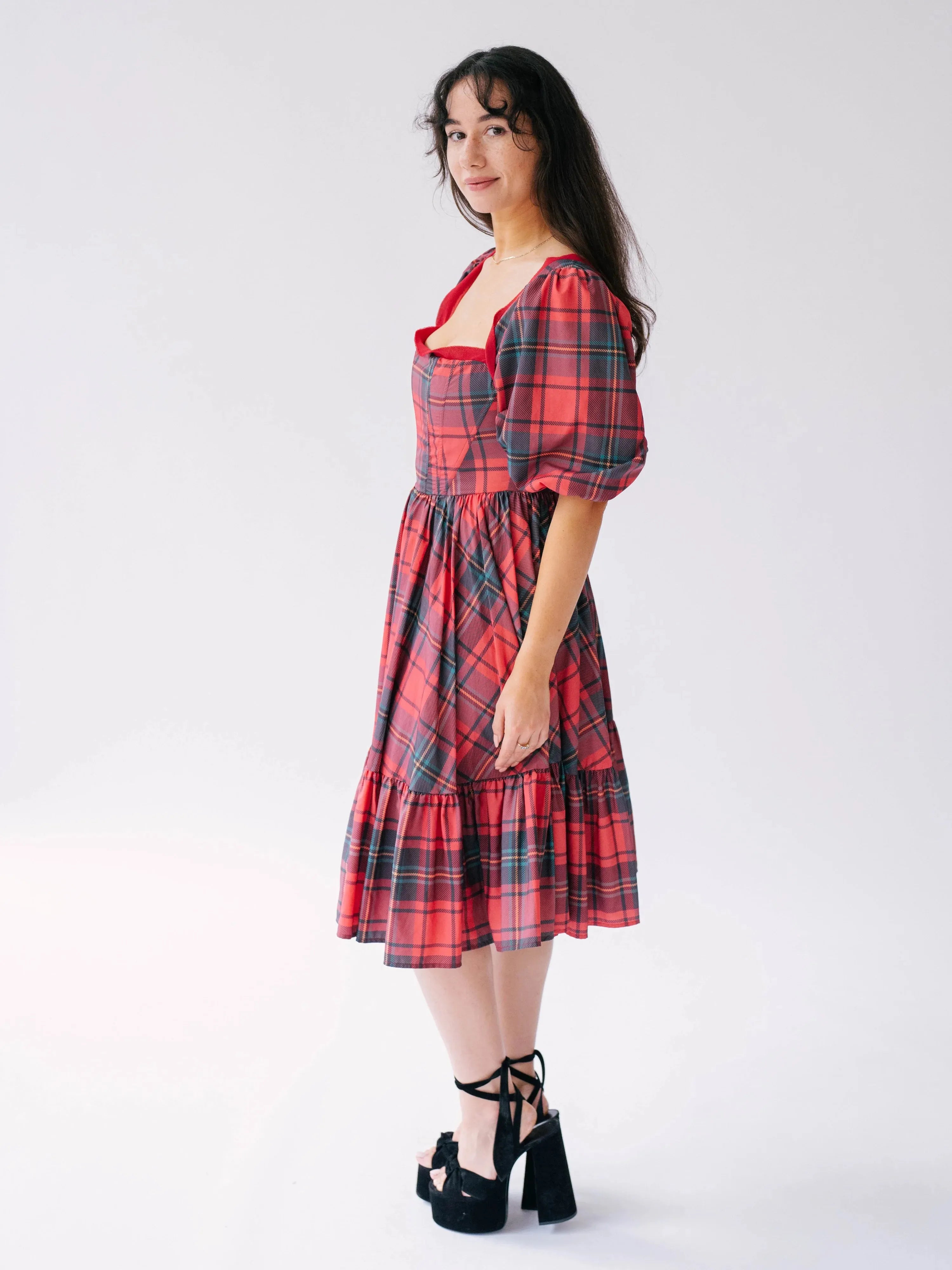 Side view of a woman wearing the Josephine tartan plaid dress against a white background.