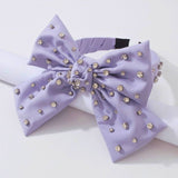 Lavender Bow Headband featuring pearl-like beads for a chic hairstyle accessory.
