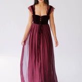 A red corset dress displayed front-facing on a woman, featuring lace-trimmed straps and a deep red corset with ribbon lacing.