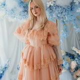 Model posing in the Midnight Symphony Organza Mini Dress surrounded by blue and white florals, showcasing its dreamy, vintage-inspired design.