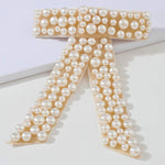 The Pearl Bow Hair Barrette featuring a stunning pearl-encrusted bow-shaped design.