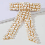 The Pearl Bow Hair Barrette featuring a stunning pearl-encrusted bow-shaped design.